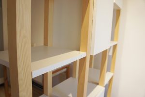 Stelaż z litego drewna, półki i szafki z białej płyty laminowanej w dwustronnym regale w stylu skandynawskim od VERYSIMPL